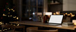 © bongkarn - A laptop on a table in a cozy home on a Christmas night, illuminated by a glowing Christmas tree.