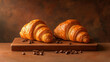 © Pimnon - Two golden croissants sit on a wooden board with coffee beans, creating a warm and inviting breakfast scene.