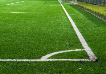 Green soccer field grass and white corner line .