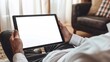 © Rocky Graphics - Businessman relaxing at home holding black tablet pc with blank white screen perfect for customization and showcasing digital content