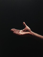 Wall Mural - outstretched hand reaching forward in a dark environment with focused details