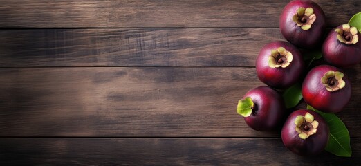 Poster - Mangosteen fruits arranged on wooden surface, vibrant purple skin, green leaves, rustic background, natural lighting, copy space for text