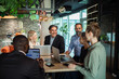 © Marko Geber - Business team collaborating on project in modern office environment