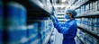© master1305 - Healthcare worker wearing mask, gloves, and medical attire is carefully organizing supplies in sterile storage facility. Safety in medical logistics.