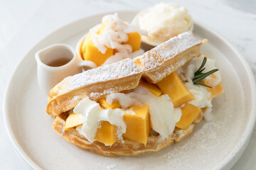 Wall Mural - Delicious waffle mango dessert with young coconut and whipped cream.