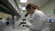 © logyartstudios - A scientist examines samples under a microscope in a laboratory setting.