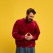 © Lustre Art Group  - Young man dressed casually, crouching of pain in stomach against bright yellow background. Viruses and symptoms. Concept of healthcare,, medicine, health insurance. ad