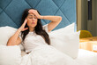 © boryanam - Young woman laying in the bed with headache .Insomnia concept