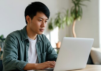 Poster - Young man concentrating on his laptop, working remotely in a bright home office