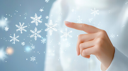 Poster - Creating winter magic with a finger touch and falling snowflakes in a serene blue background