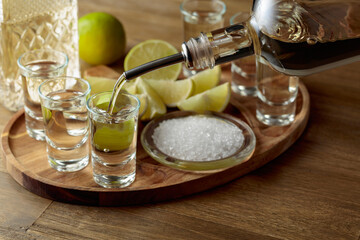 Wall Mural - Gold tequila with salt and lime slices.