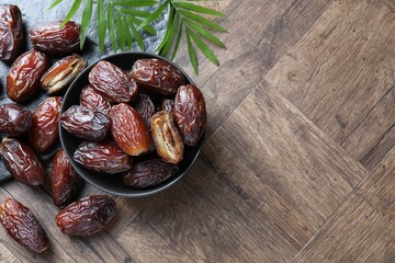 Wall Mural - tasty dried dates and leaves on wooden table, flat lay. space for text
