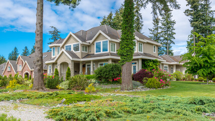 Wall Mural - Two story stucco luxury house with nice summer  landscape in Vancouver, Canada, North America. Day time on June 2024.