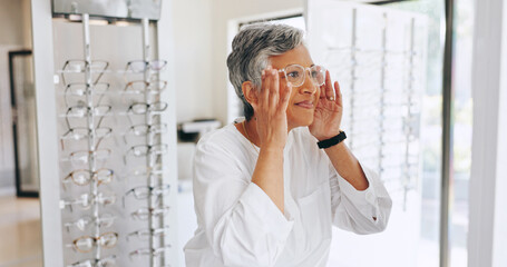 Mature woman, glasses and shopping in mirror with choice, optometry and smile with healthy vision. Person, client and customer with decision for prescription eyewear, change or fitting frame at store