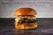 © ADDICTIVE STOCK - Juicy gourmet burger with toppings on a dark background