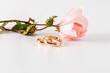 © ADDICTIVE STOCK - Elegant wedding rings with delicate rose on white background