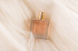 © ADDICTIVE STOCK - Elegant square perfume bottle on sheer fabric background