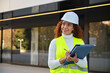 © ADDICTIVE STOCK - Latin engineer in safety gear with clipboard in urban setting
