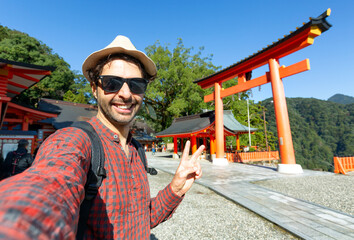 handsome young tourist enjoying summer holiday in japan - traveling life style concept with smiling 