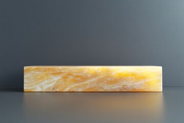 Leinwandbilder - Honey onyx rectangular block on dark grey background.