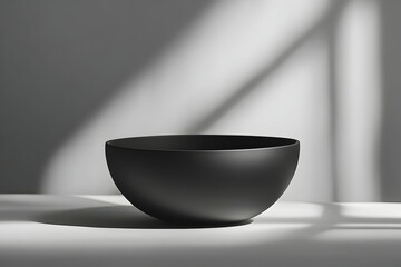 Poster - Black bowl on white surface in sunlight.