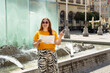 © mdyn - Happy 30s young female tourist is exploring new city. Woman holding a paper map on central square in Wroclaw old town in Poland. High quality photo, summer time. Vacation concept