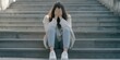 © ArtPixel-Portfolio - Lonely woman with depression sitting alone on city steps, feeling sad and anxious while covering her face