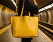 © Viktor Petrushenko - A woman holds a vibrant yellow tote bag at a subway station, exuding style and confidence.