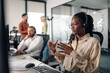 © Zamrznuti tonovi - Customer service representative gesturing while talking on a headset in a busy office