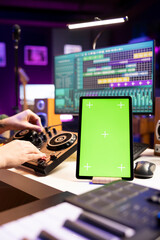 Leinwandbilder - Producer editing soundtracks on stereo tools and greenscreen layout on tablet, mixing and mastering songs in home studio. Young musician adjusting volume levels on music, daw software.