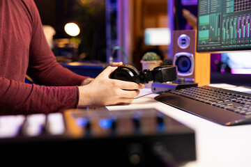 Aufkleber - Artist preparing electronic gear for audio recording session in his home studio, using headphones and mixing console to produce new soundtracks. Musician editing for music industry. Close up.