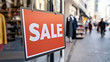 © Friedbert - Urban Street Scene Featuring Prominent Sale Sign and Blurred Cityscape Background