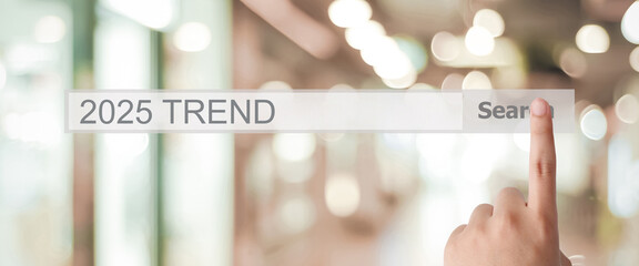 Businesman hand touching 2025 trends search bar over blur office background, banner, SEO 2022 business trends planning, success in business concept