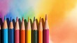 © Margo_Alexa - a row of sharpened colored pencils standing upright and casting shadows on a bright paper background.