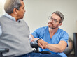 © peopleimages.com - Hospital, wheelchair and nurse with old man for consulting, support and recovery for wellness. Healthcare, talking and caregiver with elderly person with disability for rehabilitation and healing