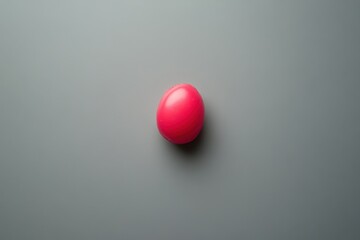 Wall Mural - A Single Pink Egg on a Gray Background