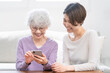 © aijiro - 若い女性にスマートフォン操作を習うシニア女性