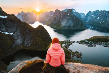 Wall Mural - travel in lofoten islands woman sitting on cliff of reinebringen mountain hiking adventure lifestyle