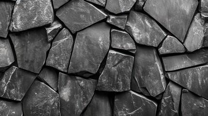 Poster - Textured black rock wall with irregular stone pieces creating a natural, rugged background suitable for various design purposes.