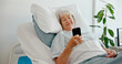 © peopleimages.com - Senior woman, hospital and smile with smartphone for messages, recovery and healing in bed. Mature person, clinic and happy texting with communication app for retirement, break and healthcare service