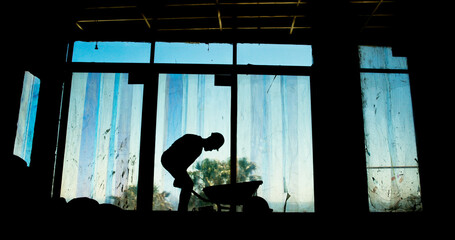 Poster - Construction site, project and worker with wheelbarrow, architecture and silhouette of employee in property. Industry, service and person with helmet for renovation, working and labor for maintenance