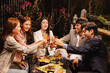 © SOMKID - Group of friends clinking wine glasses in celebration at night, Festival celebration, Happy Asian group friends and dinner party in the night, Friendship and celebration new year concept.