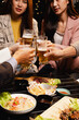 © SOMKID - Group of friends clinking beer glasses in celebration at night, Holiday, Festival celebration, Happy Asian group of friends and dinner party in the night, Friendship and celebration new year concept.