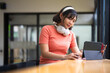 © Fahng - An attractive young Asian woman researching information and using her digital tablet at a table indoors. college student, freelancer, writer