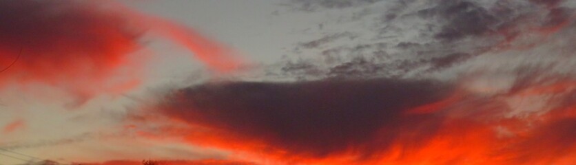 Wall Mural - Beautiful fiery red sunset with black clouds at sunset in Florida nature