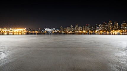 Poster - Night view of a city skyline with illuminated buildings and a calm waterfront.