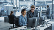 © Gorodenkoff - Portrait of Young Male Assembly Line Worker and Hispanic Female Engineer Collaborating on a Project, Using Computer and Talking in a Factory with Robotic Arms Producing Modern High Tech Devices.