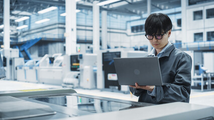 Poster - Asian Male Technician Using Laptop Computer To Control Soldering Jet Printer On Electronics Factory. Man Working On Production Of Innovative Printed Circuit Boards For Machine Learning Systems.