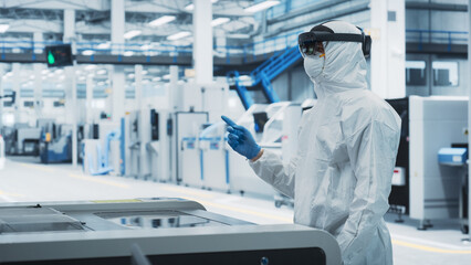 Fototapete - Sterile Coverall Wearing Engineer Uses Augmented Reality Headset to Interact With Models of Silicon Microchip in Manufacturing Facility, Precision Engineering of Advanced Computer Hardware