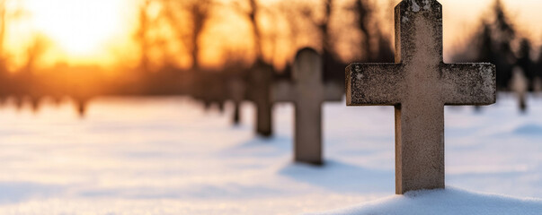 Wall Mural - stone crosses partially covered in snow in a winter graveyard at sunset, evoking a tranquil and somb